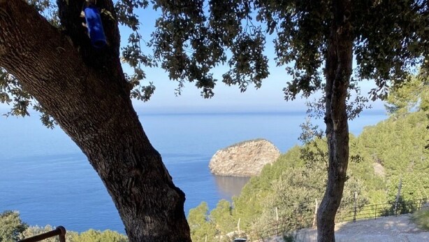 A table set outdoors with a view of the sea, a bottle of wine, and a pot of soup. - Shelter "Es Mirador" Cami de S'Illeta - Port de Soller (Puerto de Sóller)