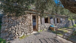 A stone cottage with a gravel driveway and a metal gate. - Shelter "Es Mirador" Cami de S'Illeta - Port de Soller (Puerto de Sóller)