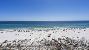 Une plage de sable blanc, un ciel bleu azur et l’océan.