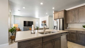 A modern kitchen with a large island, stainless steel appliances, and dark wood cabinets. - Lazy River Retreat, LOADED WITH EXTRAS! (Washington)