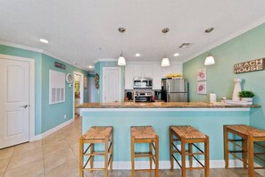 Enjoy cooking in this well-equipped kitchen with a central island, sink, and bar stools.