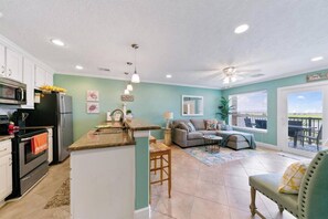 Cozy living space with a kitchenette, dining area, and seating area, offering a view of the outdoors.