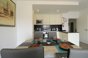 A modern kitchen with a dining area set for a meal.
