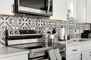 A modern kitchen with a stainless steel oven, microwave, and coffee maker.