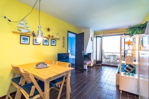Cozy room with a dining table, kitchenette, and adjacent bedroom.