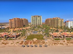 A resort with multiple buildings, a central courtyard, and surrounding palm trees.