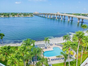 A coastal resort with a swimming pool, palm trees, and a bridge. - Waterfront 2BR condo with pool, hot tub, balcony, and water views. (St Petersburg)