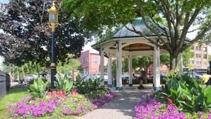 A gazebo named "HATHORNSPRING" with a pathway lined by flowers and a lamp post.
