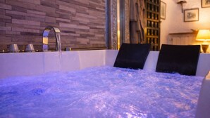 Ein Whirlpool mit Steinwand und Fenster.