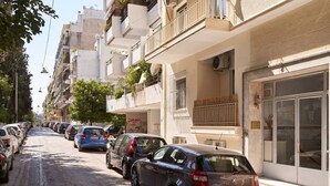 A row of parked cars along a street with multi-story buildings, balconies with plants, and a clear sky. - Hilton-Ilisia Park 2Bd Elite Living (Athina)