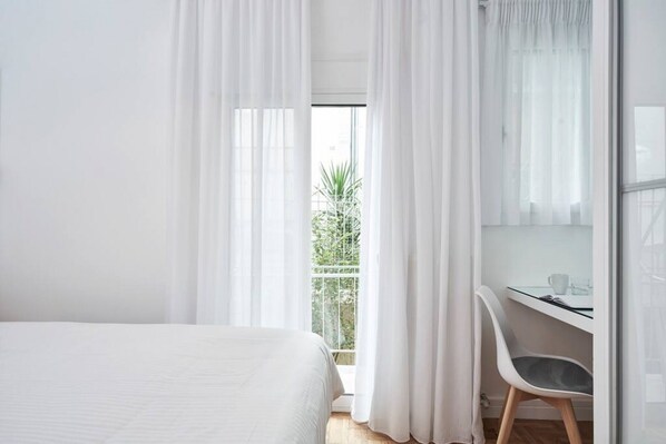 2 habitaciones, escritorio y tabla de planchar con plancha