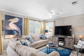 Relax in this stylish living room with a large TV, comfortable sofa, and a cozy reading nook.