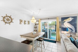 Enjoy a nautical-themed room with a dining table, sofa, and large painting of a pelican.
