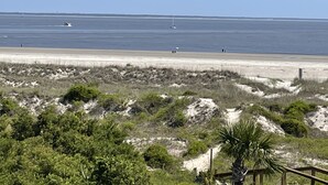 A coastal landscape with a sandy beach, sparse vegetation, and a clear view of the ocean. - Your Tybee Island Escape – Oceanfront Condo 20C (Tybee Island)