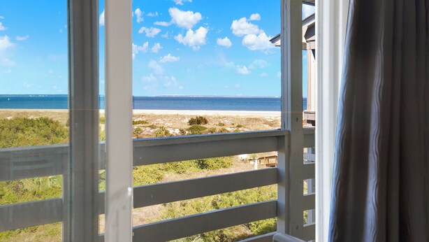 A view from a window overlooking a beach with a clear sky. - Your Tybee Island Escape – Oceanfront Condo 20C (Tybee Island)