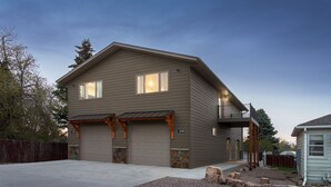 Een tweelaags huis met garage, balkon en een gevel van natuursteen.