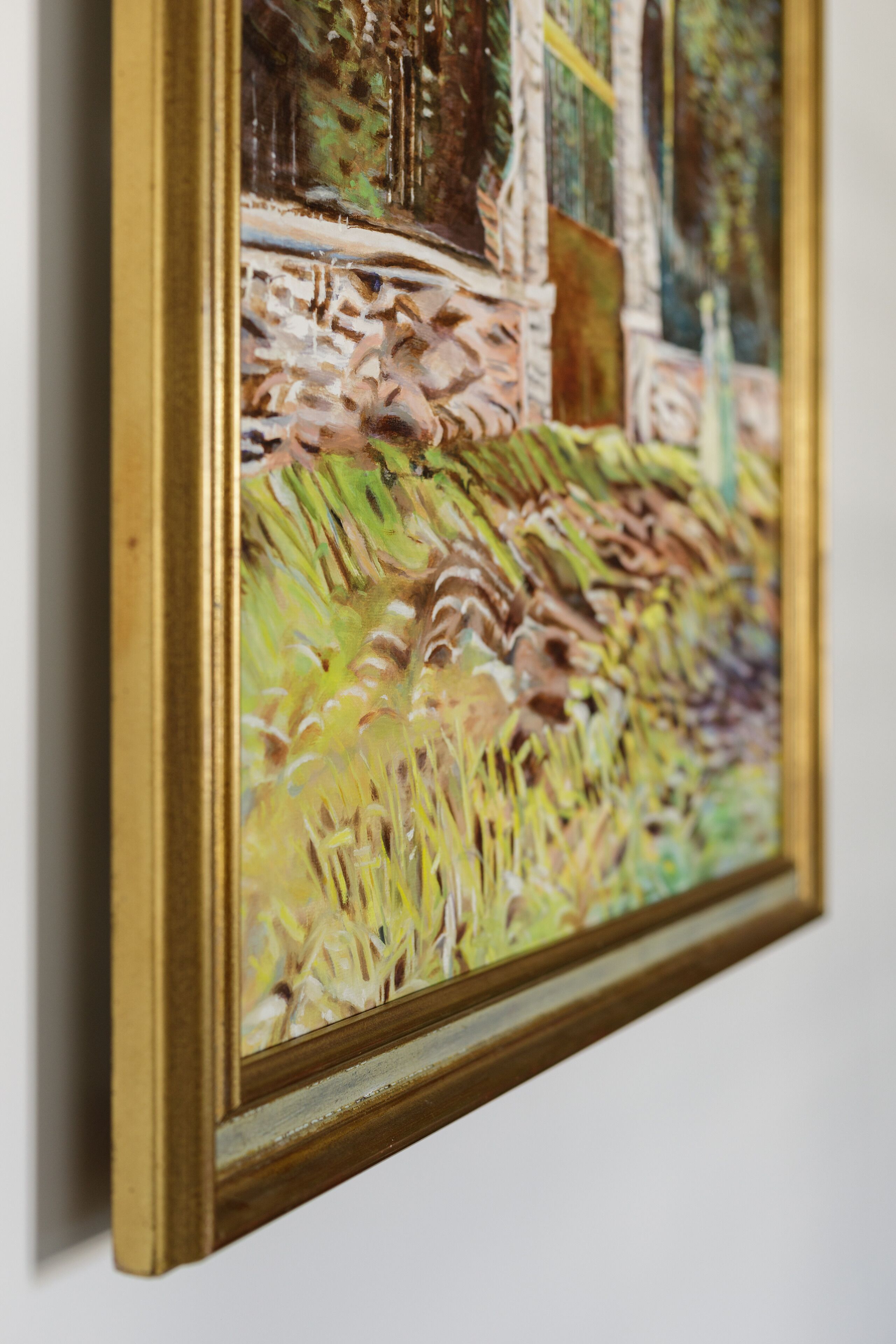 A framed painting with a landscape scene.