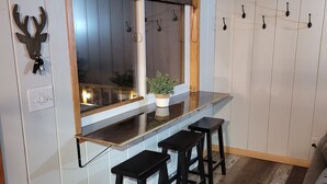 Une cuisine avec un plan de travail en bois, une fenêtre donnant sur un beau paysage et une plante posée sur le plan de travail.