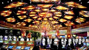 Un casino doté de nombreux distributeurs automatiques de jeux et d’un grand lustre central.