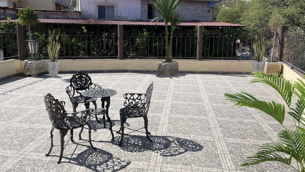 Un espace patio aménagé avec du mobilier d’extérieur et des plantes en pot.