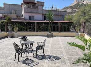 Un'area patio con mobili da esterno e piante in vasi.