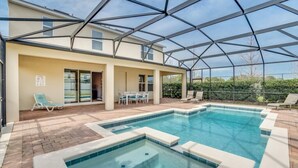 An outdoor swimming pool with a glass enclosure, lounge chairs, and a patio area with a table and chairs. - 6 bedroom 5 bathroom with Spa and Games Room Brand New Modern Furnishings (Davenport)