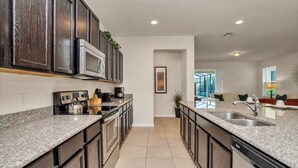 A modern kitchen with granite countertops, stainless steel appliances, and dark wood cabinets. - 6 bedroom 5 bathroom with Spa and Games Room Brand New Modern Furnishings (Davenport)