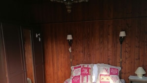 A bedroom with a wooden ceiling, a bed with a pink and white quilt, two bedside lamps, and a wooden wardrobe. - Near thermal baths and beach, 2-room apartment for rent in 2* chalet (Grésy-sur-Aix)