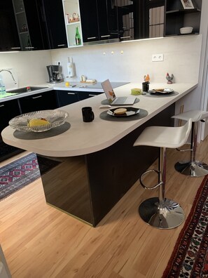 A modern kitchen with a central island, bar stools, and a laptop. - Completely refurbished, renovated bright apartment!!! (Budapest)