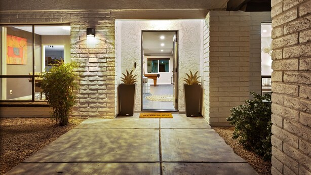 A modern building entrance with a stone facade, a welcoming mat, and a view into the interior. - Scottsdale Relaxation by the Pool! (Scottsdale)