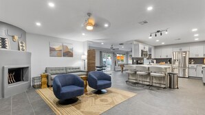 A modern living room with a grey sofa, two blue armchairs, and a patterned rug. - Scottsdale Relaxation by the Pool! (Scottsdale)