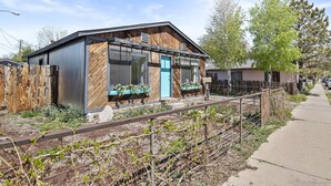 Un bâtiment de style rustique, avec une façade en bois, de grandes fenêtres et une porte bleue.