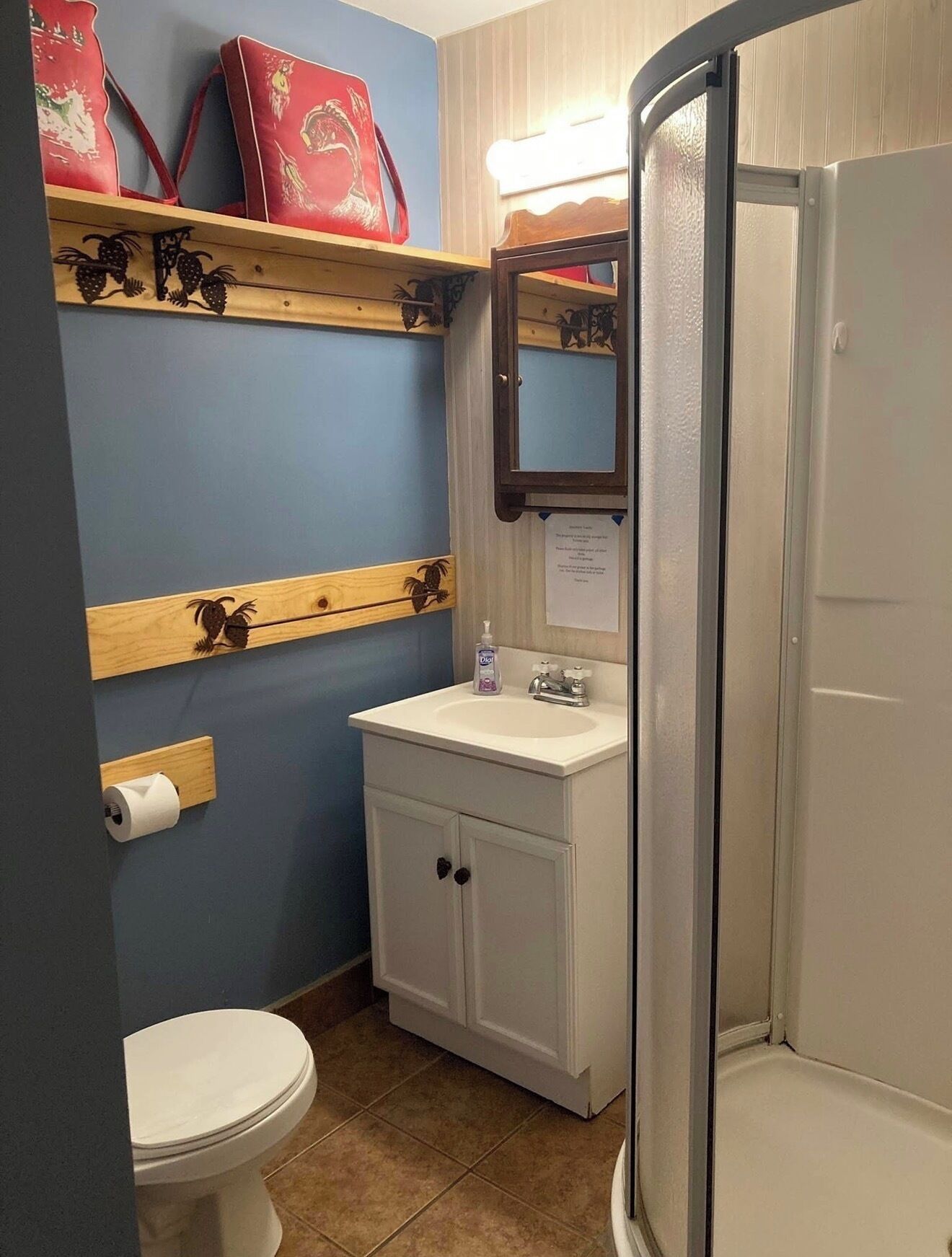 A bathroom with a toilet, sink, and shower.