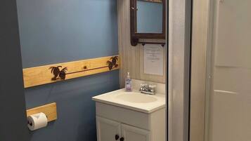 A bathroom with a toilet, sink, and shower.