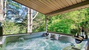 A hot tub with a wooden deck, surrounded by lush greenery and trees. - Gorgeous Views! Secluded | HotTub | Quiet & Cozy (Townsend)