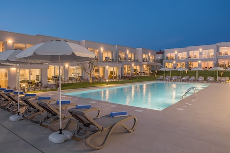 Una piscina al aire libre de temporada, sombrillas