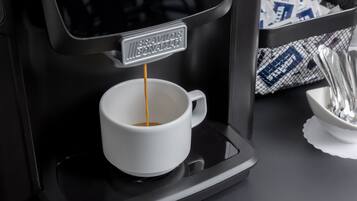 Una máquina de café sirviendo café en una taza blanca.
