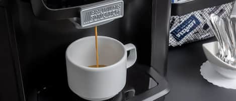 A coffee machine dispensing coffee into a white cup.
