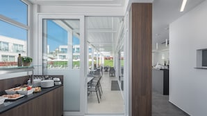 Uma cozinha moderna com área de buffet, grandes janelas e vista para área externa.