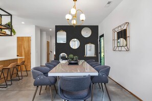 A modern dining area with a long table, multiple chairs, and a chandelier. - Alexander Dr 7 Minutes to Northshore (Chattanooga)