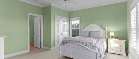 A bedroom with a bed, nightstand, and a ceiling fan.