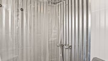 Un cerramiento de ducha con pared de metal corrugado y un cabezal.