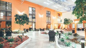 A spacious indoor courtyard with a central fountain, surrounded by seating areas and potted plants.