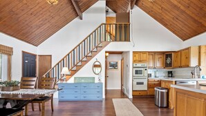 A spacious kitchen with wooden cabinets, a built-in oven, and a stainless steel sink.