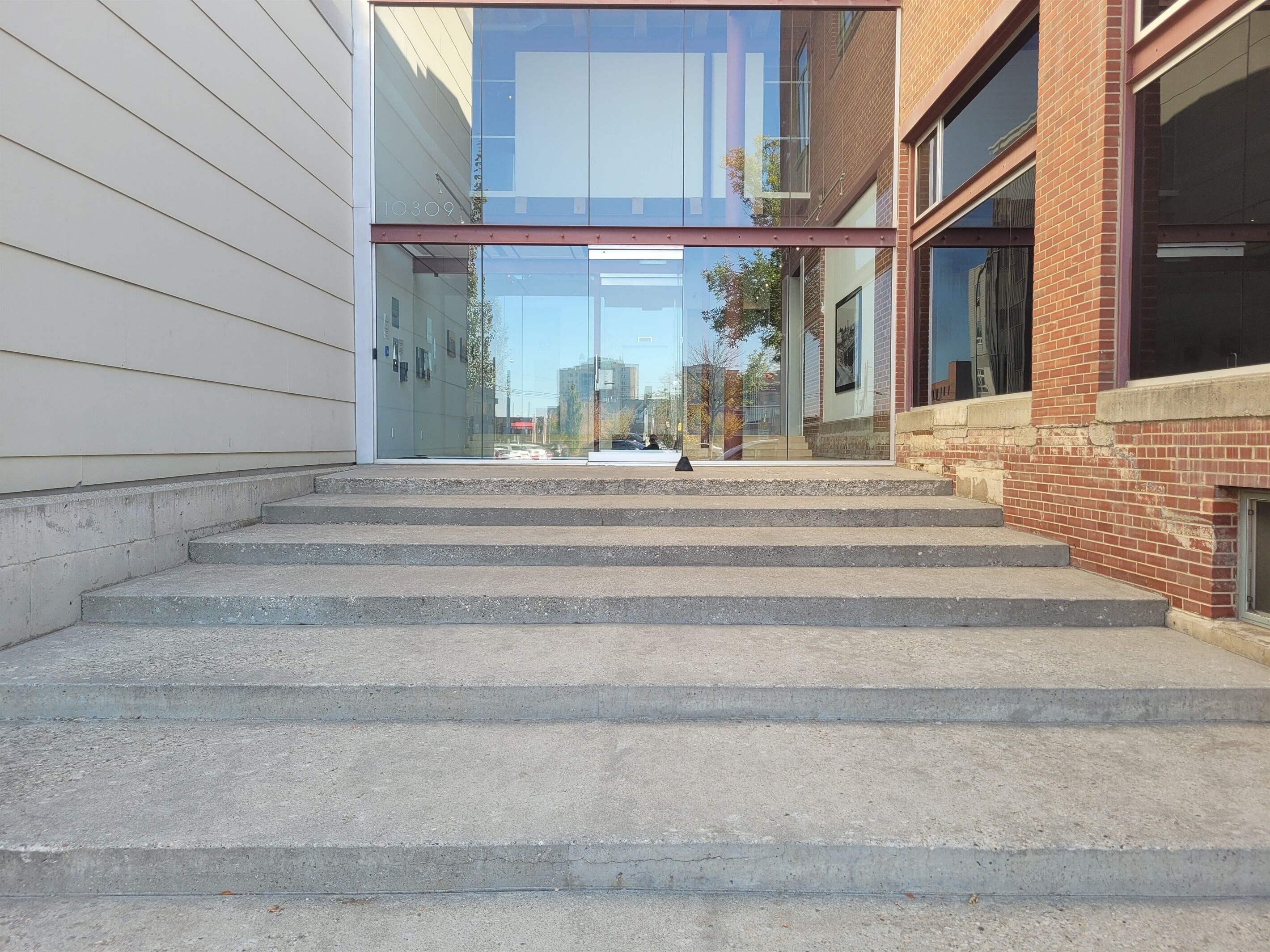 A staircase leading to a modern building with glass and brick architecture.