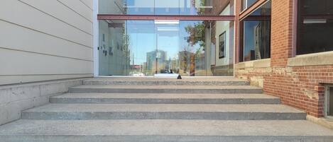 A staircase leading to a modern building with glass and brick architecture.