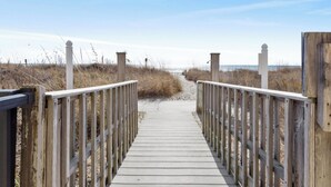A wooden boardwalk leading to a beach with sand and grass on either side. -  Sea Castle 5E. Fastidiously Clean  Ocean Front Condo RENOVATED (North Myrtle Beach)