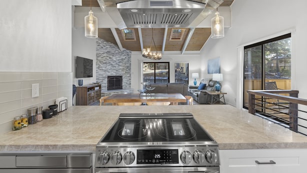 A modern kitchen with a large island, stainless steel appliances, and a stone backsplash. - Newly Rennovated and Air Conditioned Townhouse -1 mile from Skiing (Incline Village)