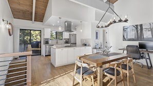A spacious kitchen with a large island, wooden ceiling beams, and a dining area with a table and chairs. - Newly Rennovated and Air Conditioned Townhouse -1 mile from Skiing (Incline Village)