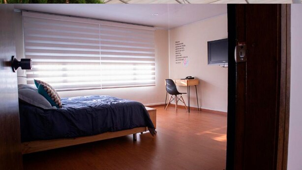 Une chambre à coucher avec un lit, un bureau et une chaise.